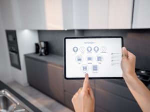 Smart home monitoring system control panel displayed on a tablet in a modern kitchen environment.