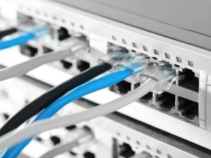 Close-up of network cables connected to an IT networking switch panel in a data center.