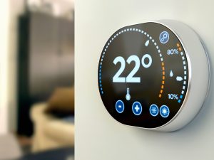 Smart thermostat with energy monitoring features, indicating 22 degrees Celsius and energy usage.