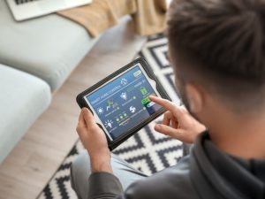 A man uses a tablet to monitor energy usage in his smart home, with ECO mode activated.