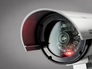 A close-up of a security camera lens with a red light, hinting at the possibility of blurry CCTV footage.